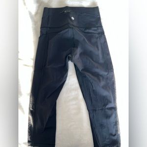 Black 3/4 Lululemon leggings with zipper pocket and breathable sides, Size 25